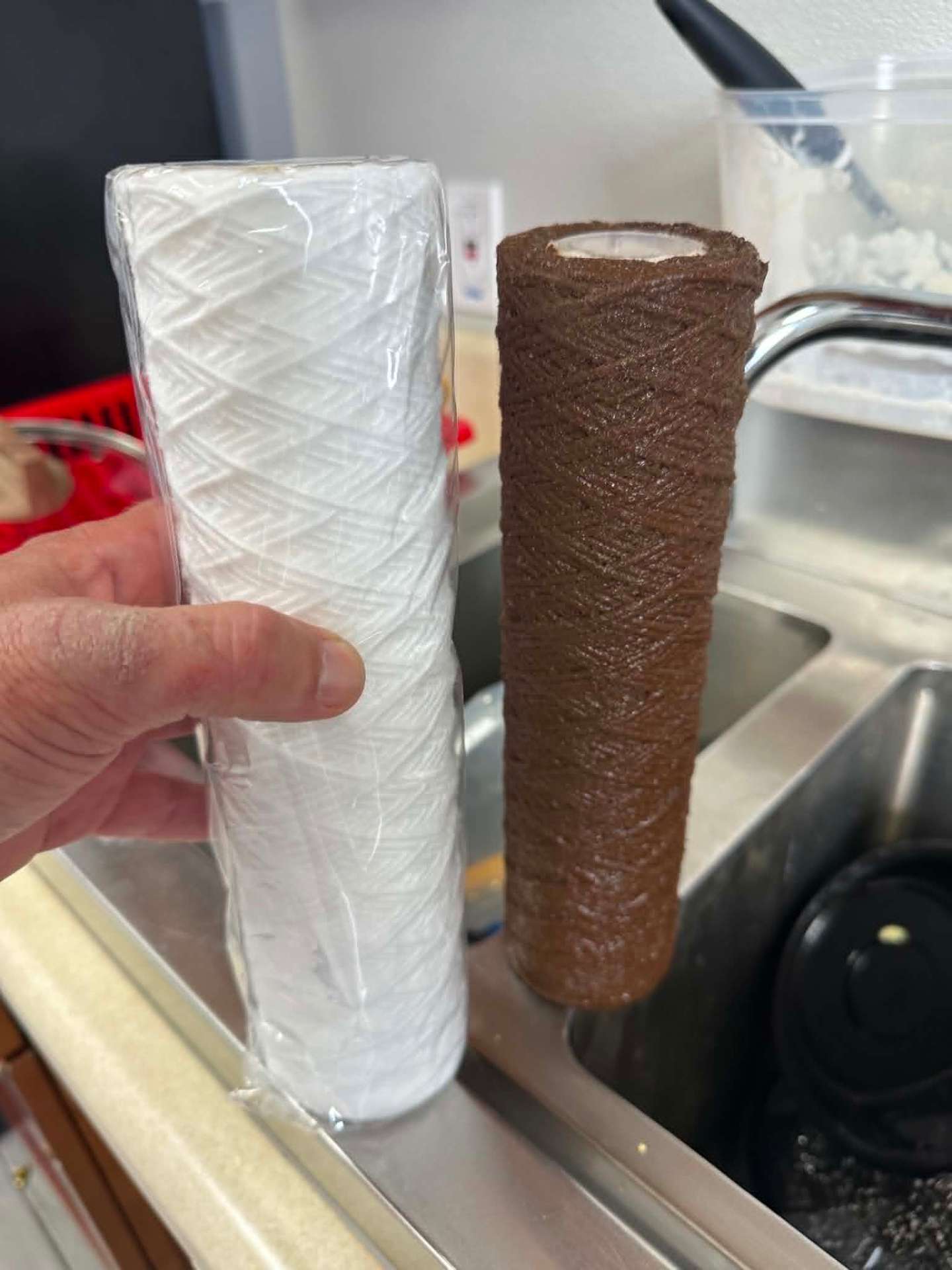 New white sediment filter next to a used brown one